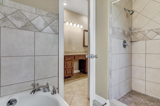 bathroom featuring tile patterned floors, vanity, and shower with separate bathtub