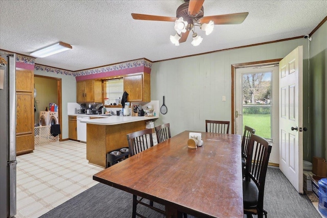 dining room featuring independent washer and dryer, a textured ceiling, light floors, and ornamental molding