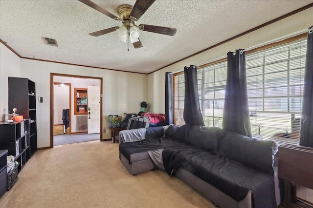 living room featuring visible vents, light carpet, ornamental molding, a textured ceiling, and ceiling fan