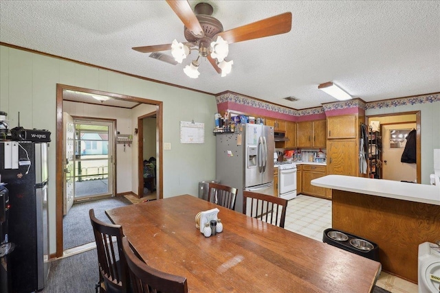 dining room featuring visible vents, light floors, ornamental molding, a textured ceiling, and a ceiling fan