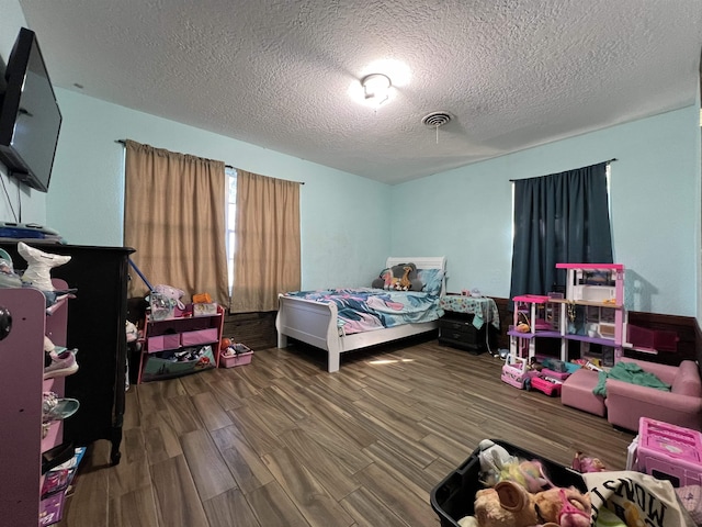 bedroom featuring a textured ceiling and dark hardwood / wood-style floors