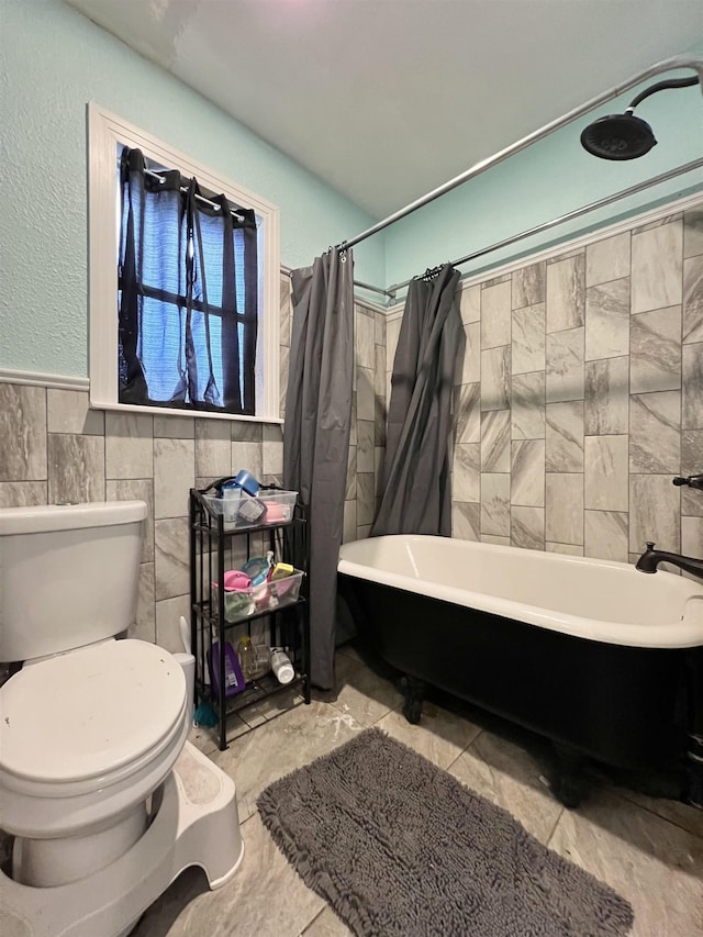 bathroom with shower / tub combo, toilet, tile walls, and tile patterned floors