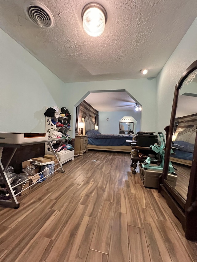 bedroom with hardwood / wood-style floors and a textured ceiling