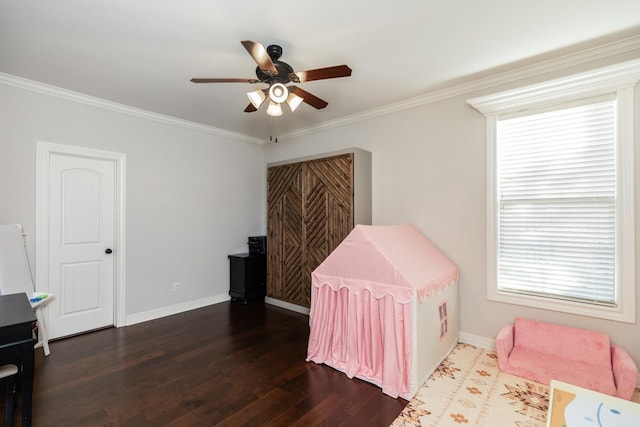 recreation room featuring ceiling fan, dark hardwood / wood-style flooring, and ornamental molding