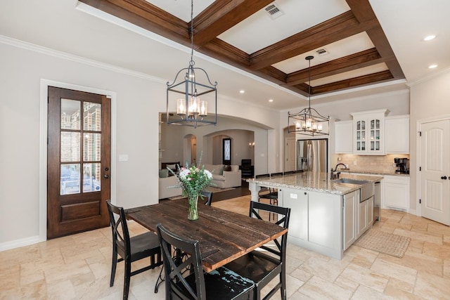 dining area featuring beam ceiling, sink, ornamental molding, and coffered ceiling