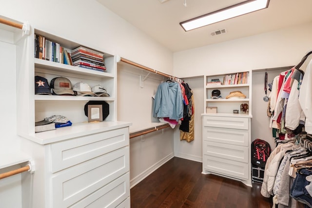 spacious closet with dark hardwood / wood-style flooring