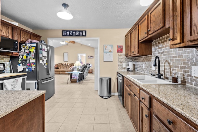103 Read St, Silsbee, TX 77656 - kitchen featuring appliances with stainless steel finishes, tasteful backsplash, light tile patterned flooring, and a textured ceiling