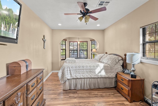 103 Read St, Silsbee, TX 77656 - bedroom featuring arched walkways, light wood-style flooring, recessed lighting, and ceiling fan