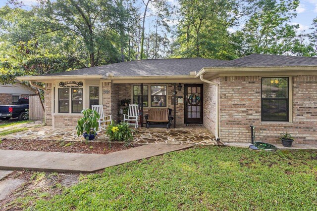 103 Read St, Silsbee, TX 77656 - single story home with a porch, a front yard, brick siding, and a shingled roof