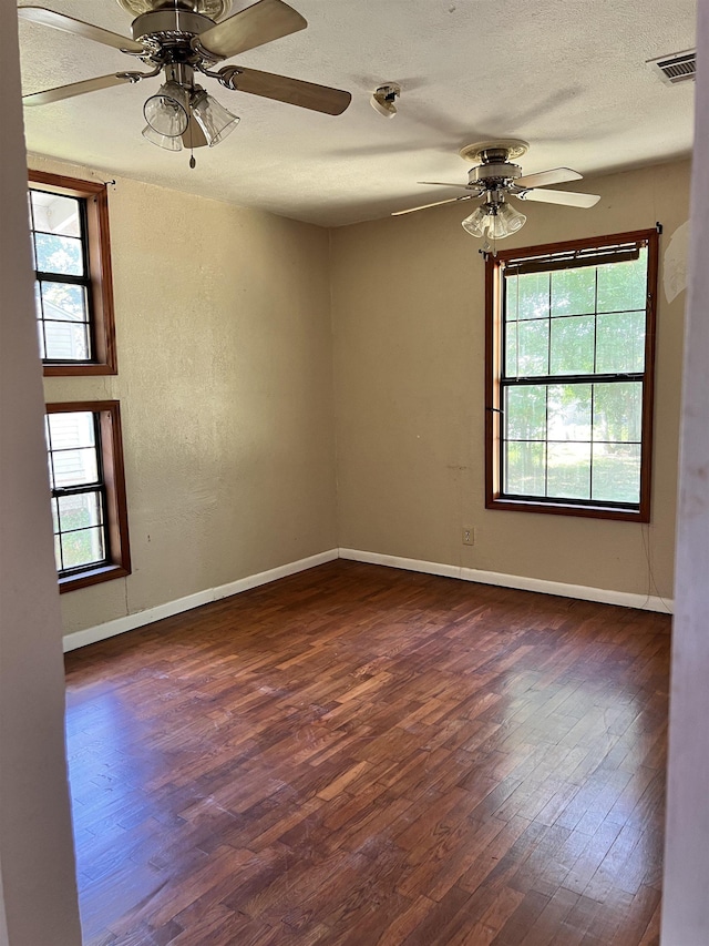 unfurnished room featuring dark hardwood / wood-style flooring, plenty of natural light, and ceiling fan