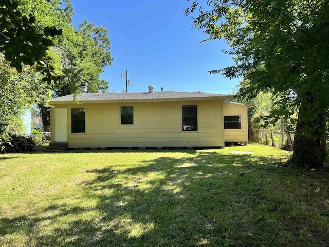 rear view of house featuring a lawn