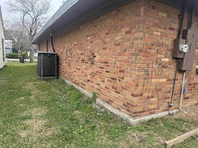 view of side of home featuring central AC and a yard