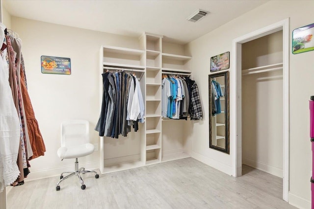 spacious closet featuring light hardwood / wood-style floors