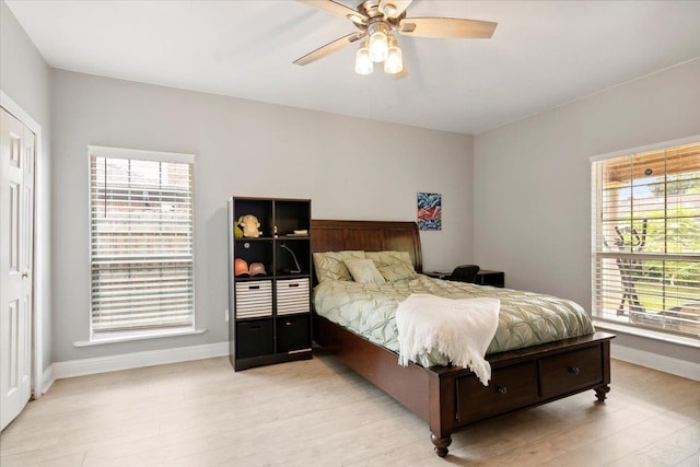 bedroom featuring multiple windows, light hardwood / wood-style floors, and ceiling fan