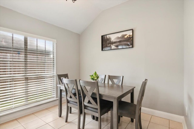 tiled dining space with vaulted ceiling