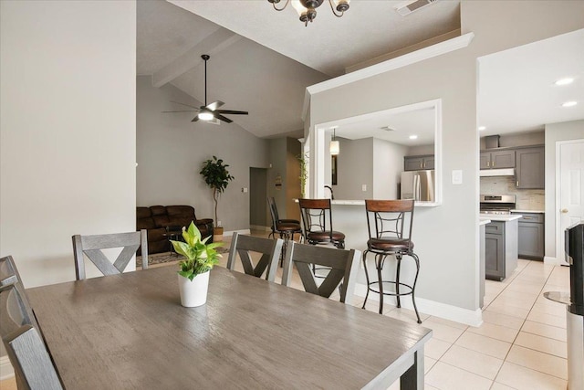 tiled dining room with ceiling fan and lofted ceiling with beams