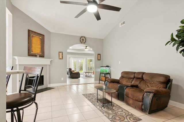 tiled living room featuring french doors, vaulted ceiling, and ceiling fan