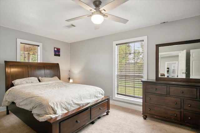 carpeted bedroom with multiple windows and ceiling fan