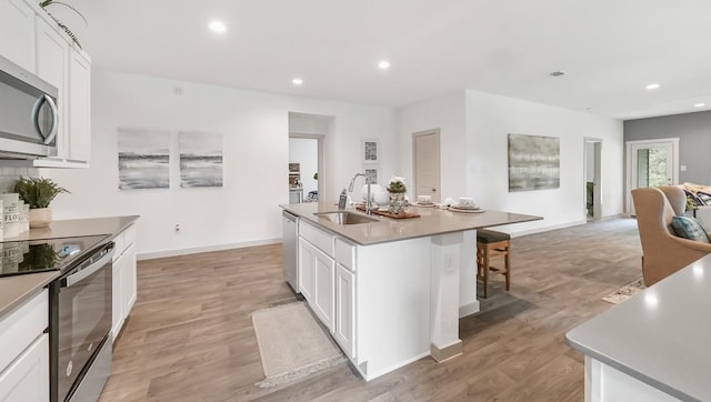 kitchen with white cabinetry, an island with sink, appliances with stainless steel finishes, and a sink