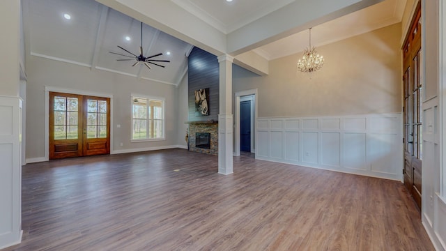 unfurnished living room featuring high vaulted ceiling, ornamental molding, hardwood / wood-style floors, a fireplace, and ceiling fan with notable chandelier