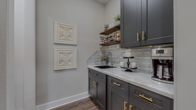 bar featuring gray cabinetry, sink, decorative backsplash, and dark hardwood / wood-style floors