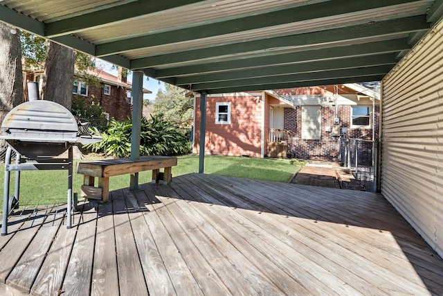 deck featuring an outdoor structure, grilling area, and a lawn