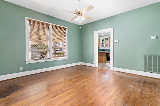 spare room with sink, hardwood / wood-style flooring, and ceiling fan