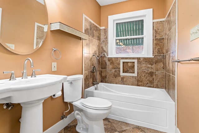 full bathroom featuring sink, tiled shower / bath combo, tile patterned floors, and toilet