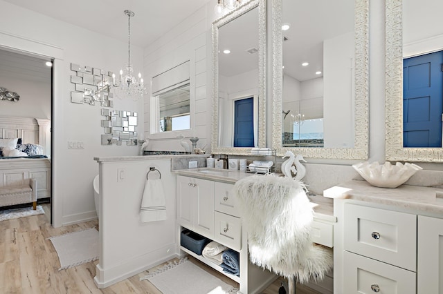 bathroom featuring vanity, wood-type flooring, and a notable chandelier