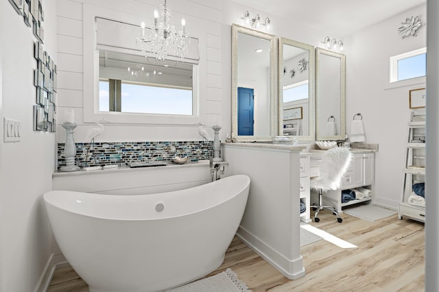 bathroom featuring wood-type flooring, vanity, plenty of natural light, and a bathing tub