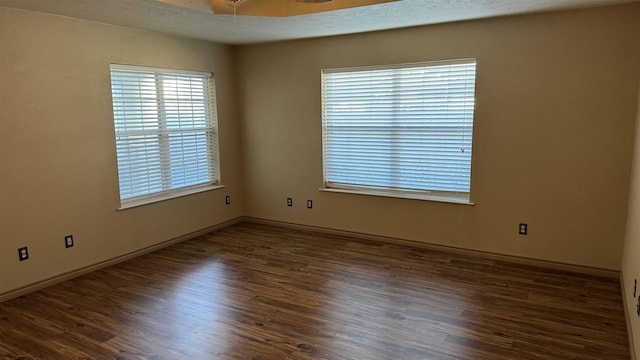 spare room with ceiling fan and dark wood-type flooring