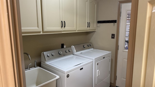 washroom featuring cabinets, independent washer and dryer, and sink