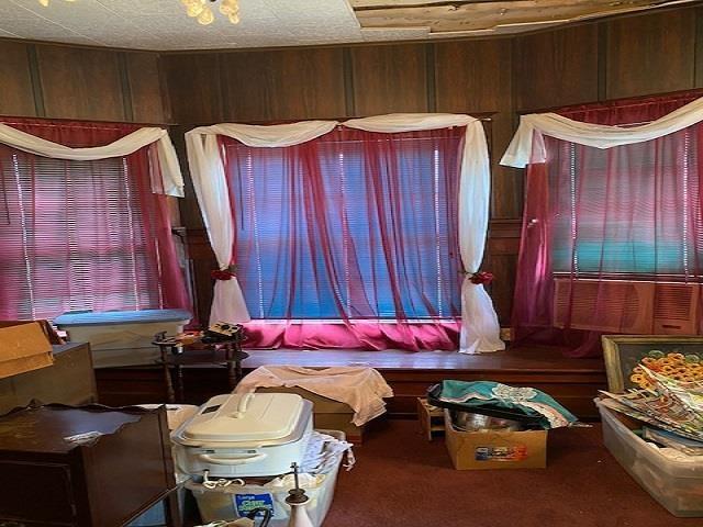 bedroom with carpet flooring and wood walls