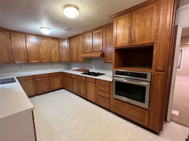 kitchen featuring oven, sink, and black gas cooktop