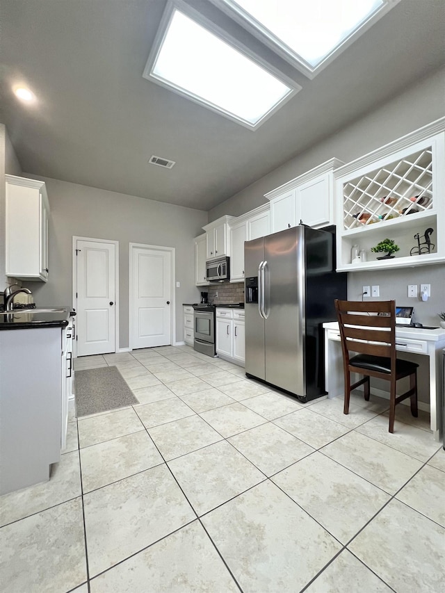 513 Harbor Oaks Dr, Beaumont, TX 77706 - kitchen with appliances with stainless steel finishes, dark countertops, white cabinets, and light tile patterned floors