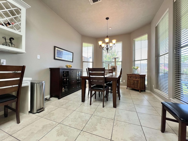 513 Harbor Oaks Dr, Beaumont, TX 77706 - dining area featuring a chandelier, a textured ceiling, light tile patterned floors, and baseboards