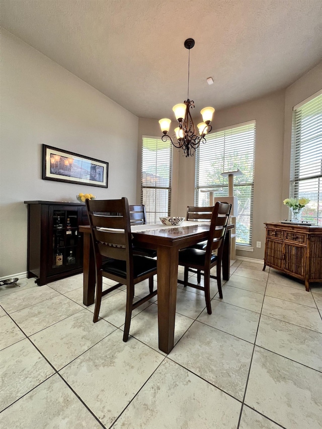 513 Harbor Oaks Dr, Beaumont, TX 77706 - dining area with a chandelier, light tile patterned floors, baseboards, and a textured ceiling