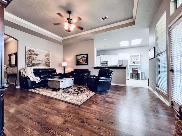 513 Harbor Oaks Dr, Beaumont, TX 77706 - living room featuring a raised ceiling, wood finished floors, ceiling fan, crown molding, and arched walkways