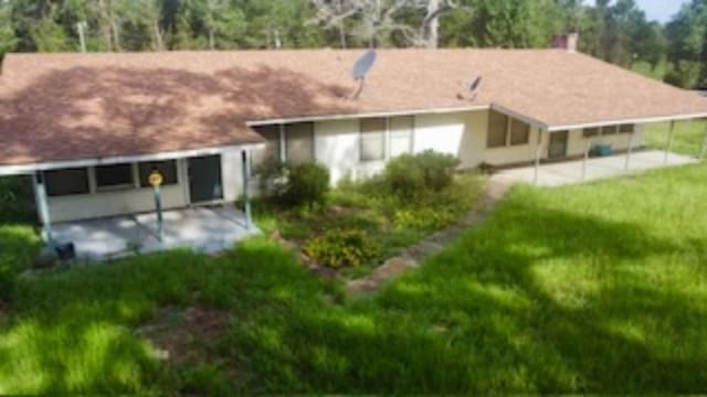 rear view of house featuring a patio and a lawn