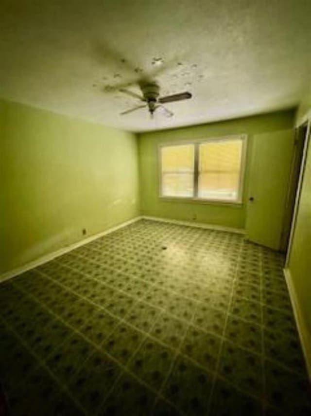 interior space featuring tile patterned floors, ceiling fan, and baseboards