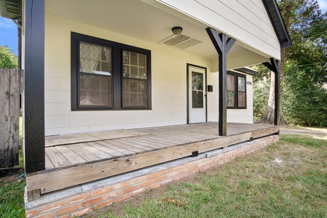 view of exterior entry featuring a wooden deck