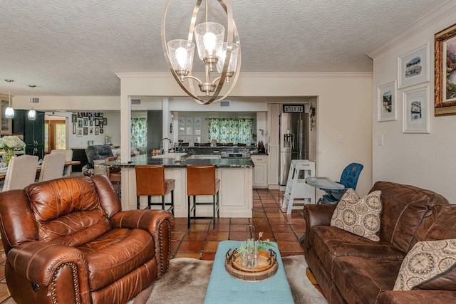 tiled living room with ornamental molding, a textured ceiling, a notable chandelier, and sink