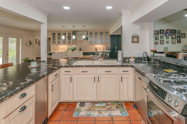 kitchen with kitchen peninsula, stainless steel range, light tile patterned floors, and sink