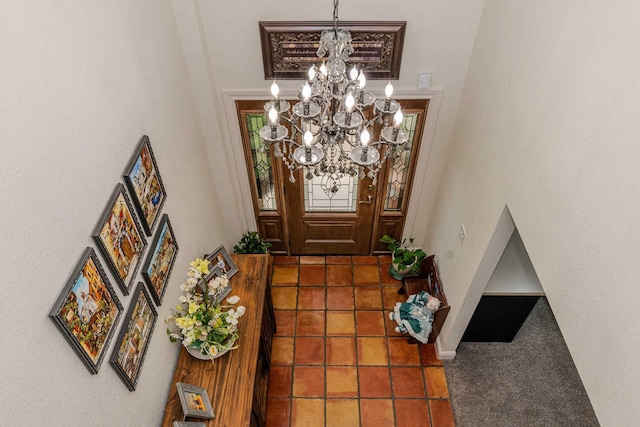 foyer with carpet floors, a high ceiling, and an inviting chandelier