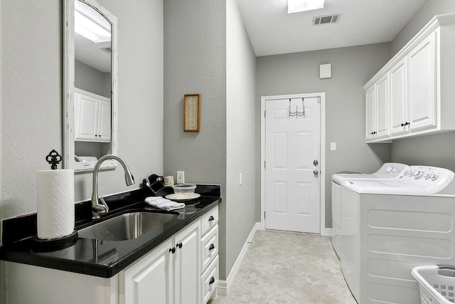 laundry room featuring cabinets, sink, and washing machine and dryer