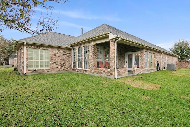 rear view of house featuring central AC and a yard