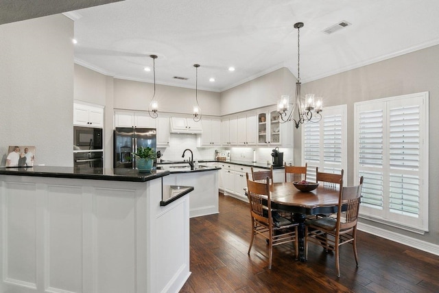 kitchen featuring dark hardwood / wood-style floors, black appliances, decorative backsplash, hanging light fixtures, and white cabinets