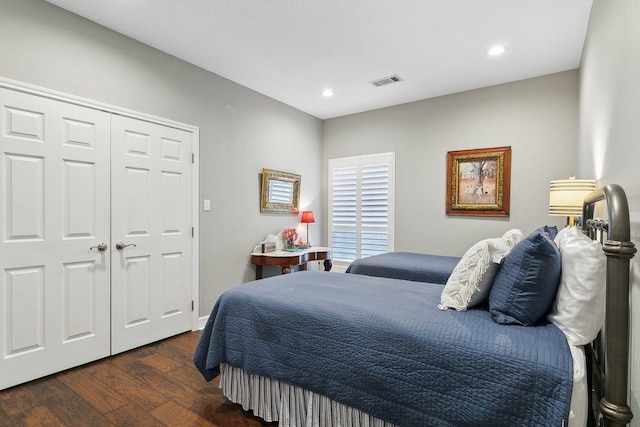 bedroom with dark wood-type flooring and a closet