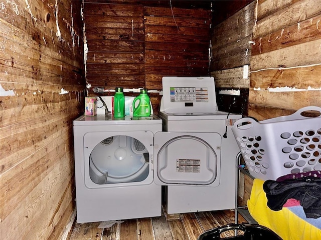 laundry room with separate washer and dryer and wooden walls