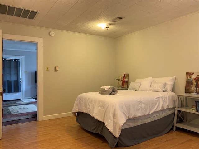 bedroom featuring light hardwood / wood-style flooring and ornamental molding